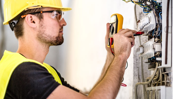 Técnico probando un circuito con un voltímetro alimentado por batería