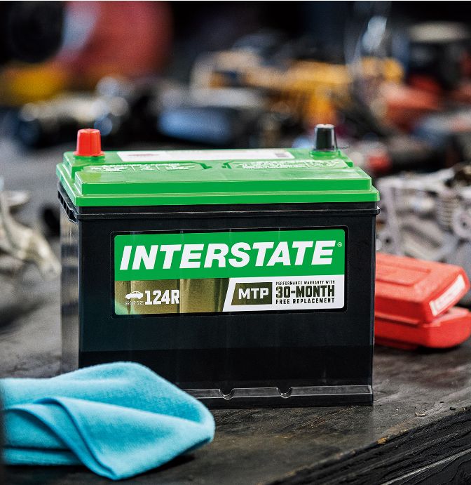 Interstate automotive battery on a workbench in an auto repair shop