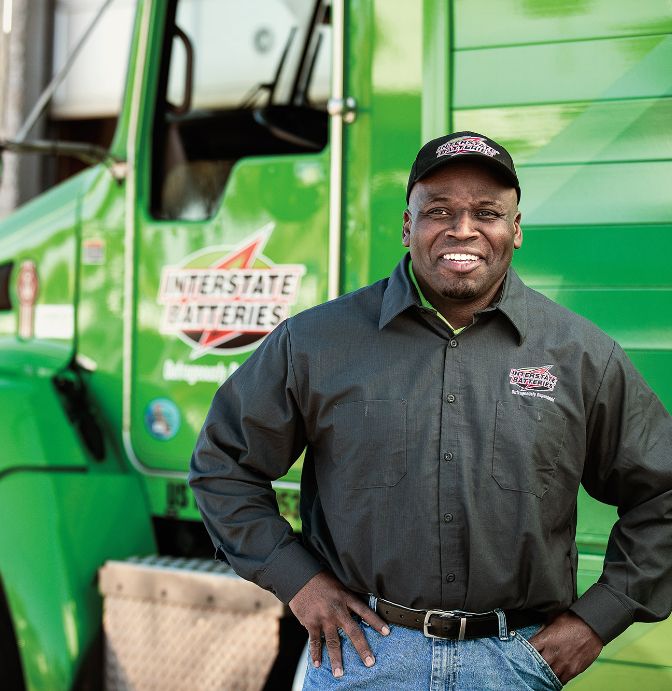 Interstate Batteries team member beside a delivery truck