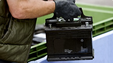person recycling a car battery